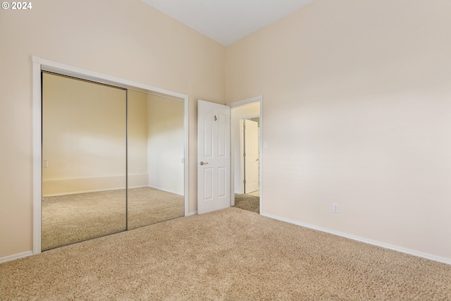 unfurnished bedroom with carpet floors, a closet, and baseboards