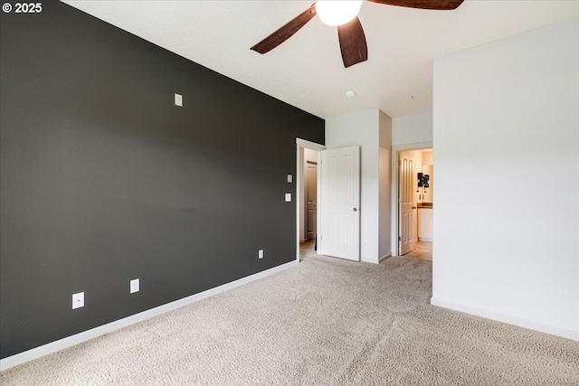 unfurnished room with a ceiling fan, baseboards, and light carpet