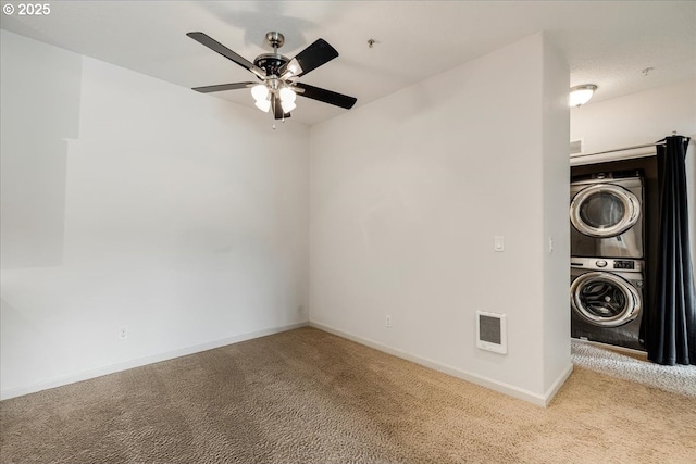 interior space with visible vents, stacked washer and dryer, a ceiling fan, and baseboards