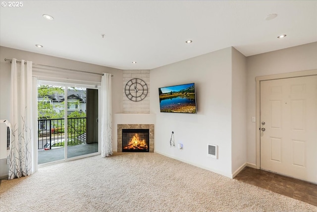 unfurnished living room featuring recessed lighting, a tiled fireplace, and visible vents