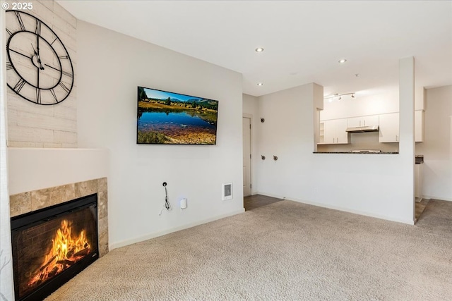 unfurnished living room featuring recessed lighting, carpet, a tile fireplace, and visible vents