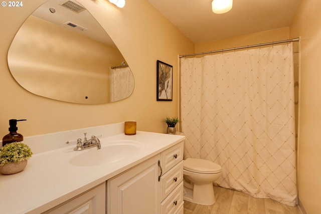 bathroom featuring toilet, vanity, and hardwood / wood-style floors