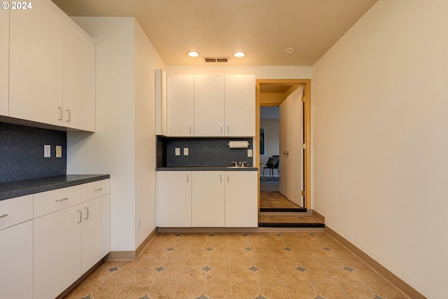 kitchen featuring white cabinetry and backsplash