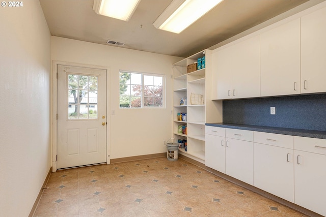 interior space featuring white cabinets and decorative backsplash