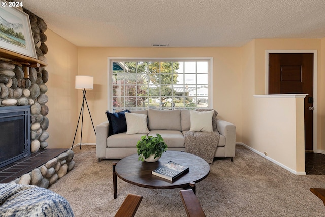 carpeted living room with a fireplace and a textured ceiling