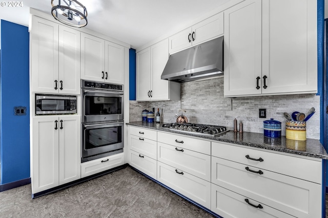 kitchen featuring dark stone counters, stainless steel appliances, white cabinets, and tasteful backsplash