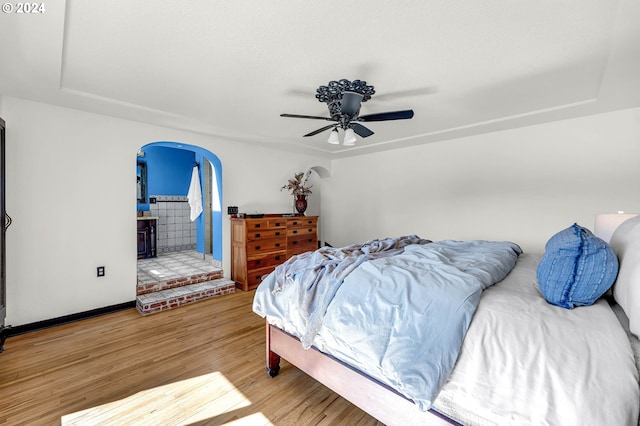 bedroom featuring connected bathroom, ceiling fan, and hardwood / wood-style floors