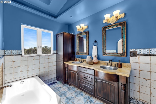 bathroom with tile walls, a tub to relax in, vanity, and tile patterned floors