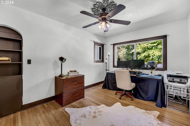 office with light wood-type flooring, ceiling fan, and a textured ceiling