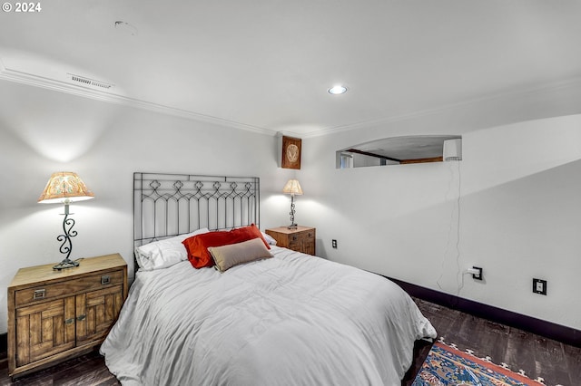 bedroom featuring ornamental molding and dark hardwood / wood-style flooring