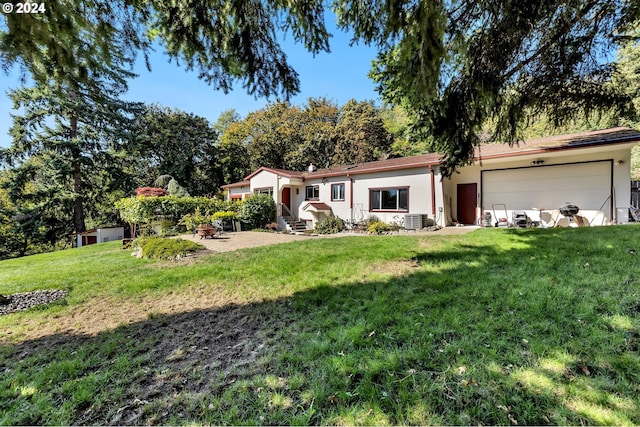 ranch-style house with cooling unit, a front yard, and a garage