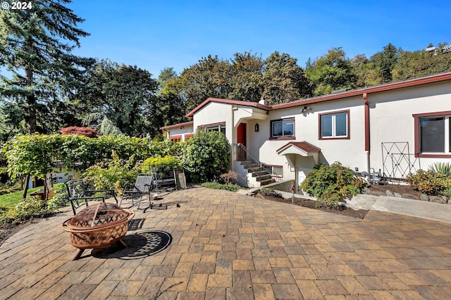 mediterranean / spanish-style home featuring a patio and a fire pit