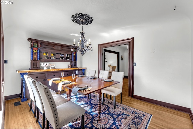 dining area featuring an inviting chandelier and light wood-type flooring