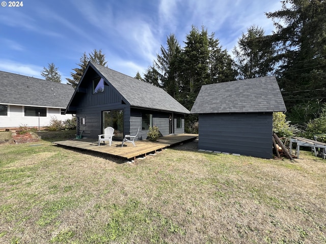 rear view of house featuring a wooden deck, a yard, and an outdoor structure