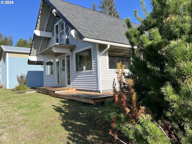 exterior space featuring a wooden deck and a front lawn