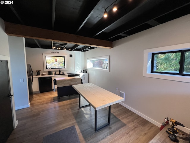 interior space featuring beamed ceiling, rail lighting, light hardwood / wood-style flooring, and sink