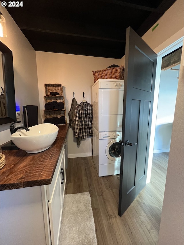 bathroom with vanity, wood-type flooring, and stacked washing maching and dryer