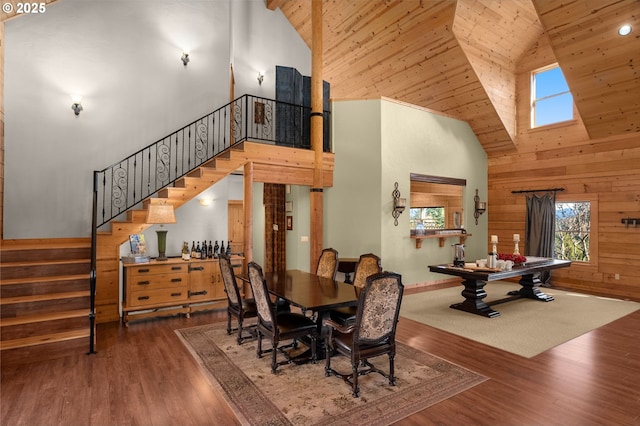 dining space with wood-type flooring, wooden walls, high vaulted ceiling, and wood ceiling