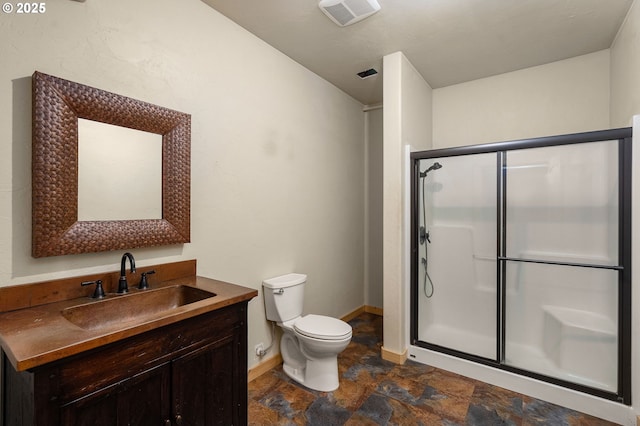 bathroom with vanity, a shower with shower door, and toilet