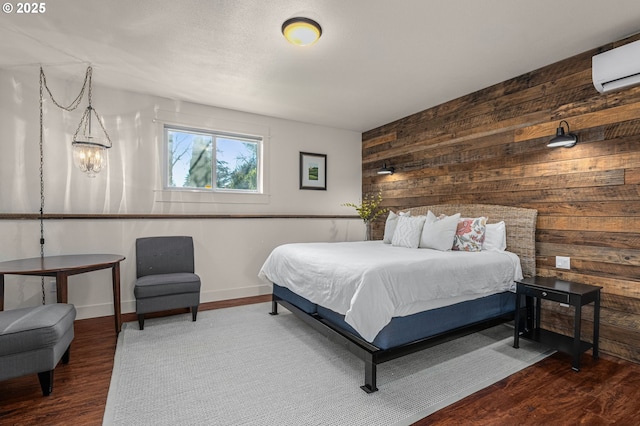 bedroom featuring wood-type flooring, wood walls, and a wall mounted AC