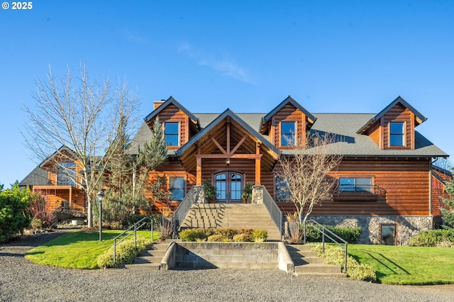 log home with french doors and a front lawn