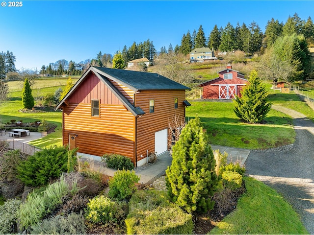 view of property exterior with an outdoor structure, a lawn, and a garage