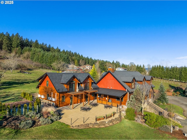 rear view of property featuring a patio area and a lawn