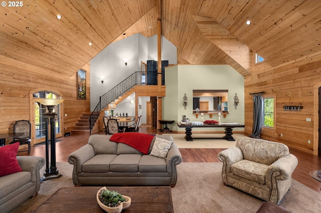 living room with high vaulted ceiling, wooden ceiling, hardwood / wood-style flooring, and wooden walls