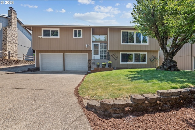 raised ranch with a garage and a front yard