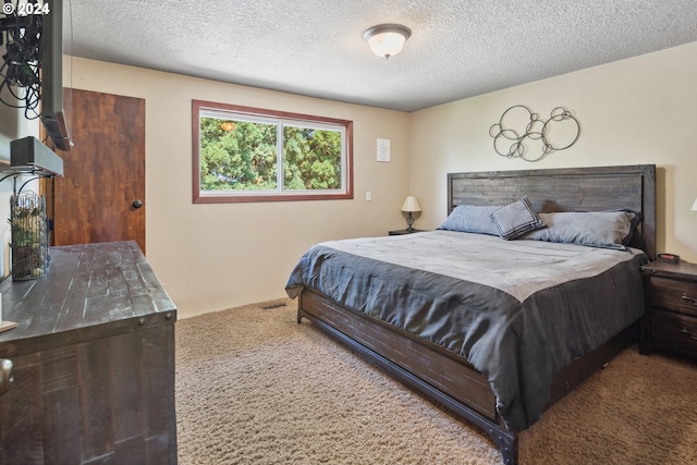 bedroom with carpet and a textured ceiling