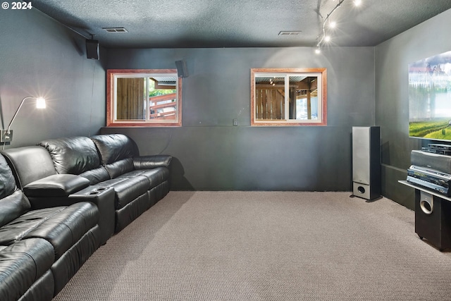 home theater featuring carpet, a textured ceiling, and track lighting