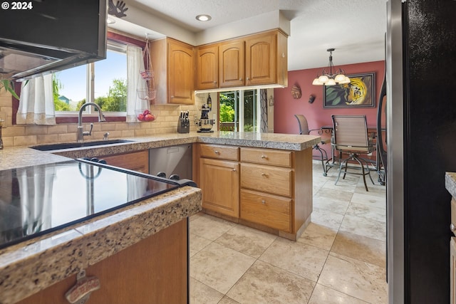 kitchen featuring stainless steel appliances, an inviting chandelier, decorative backsplash, sink, and pendant lighting