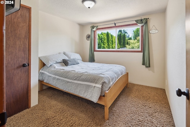 bedroom featuring carpet flooring and a textured ceiling