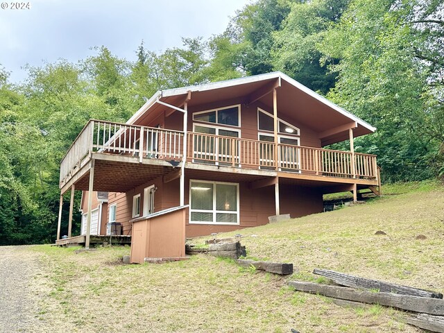 rear view of property with a yard and a wooden deck