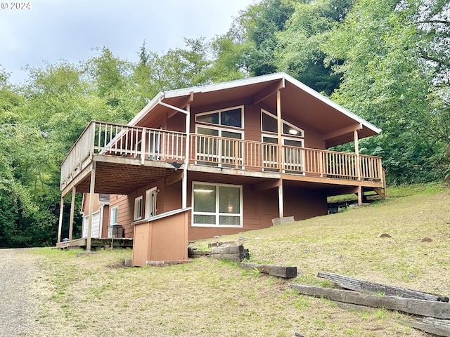 rear view of property with a lawn and a wooden deck