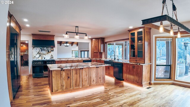 1081 Umpqua College Rd, Roseburg, OR 97470 - kitchen with range, dishwasher, exhaust hood, brown cabinetry, and light wood-style floors