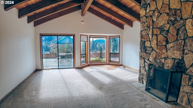 1081 Umpqua College Rd, Roseburg, OR 97470 - unfurnished living room featuring wooden ceiling with exposed beams, carpet, baseboards, a stone fireplace, and high vaulted ceiling