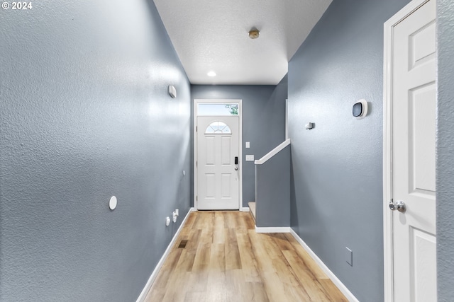 entryway with light hardwood / wood-style flooring and a textured ceiling