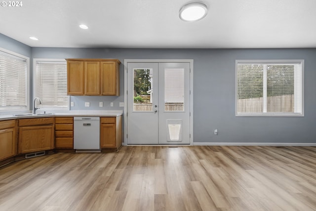 kitchen with white dishwasher, light hardwood / wood-style floors, and sink