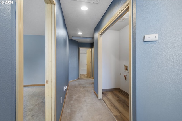 hallway featuring light colored carpet