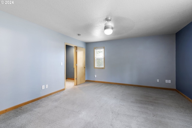 carpeted empty room with a textured ceiling