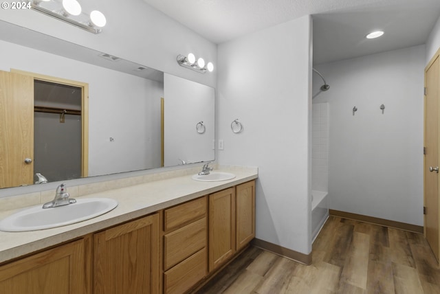 bathroom featuring shower / tub combination, vanity, and wood-type flooring