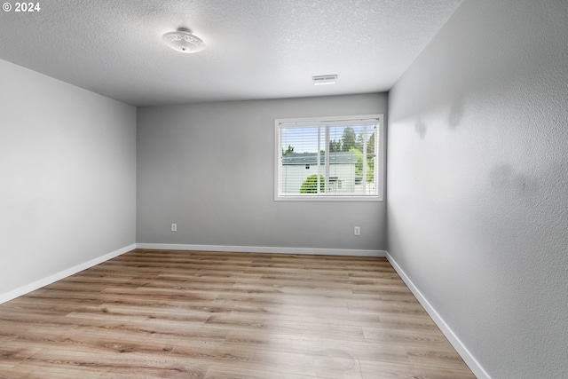 empty room featuring light hardwood / wood-style floors and a textured ceiling