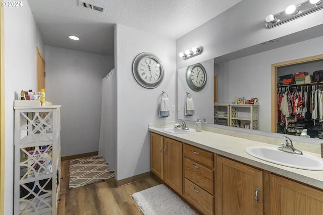 bathroom featuring vanity, wood-type flooring, and a textured ceiling