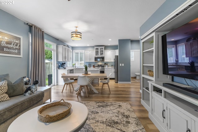 living room with sink and light hardwood / wood-style flooring