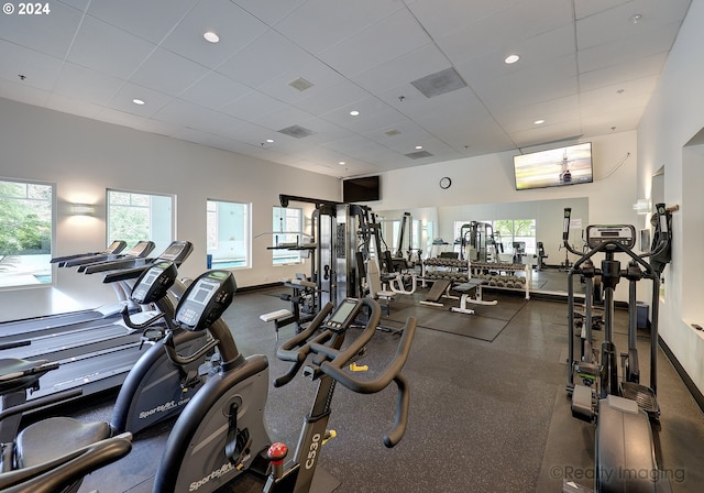 gym featuring a drop ceiling and a wealth of natural light