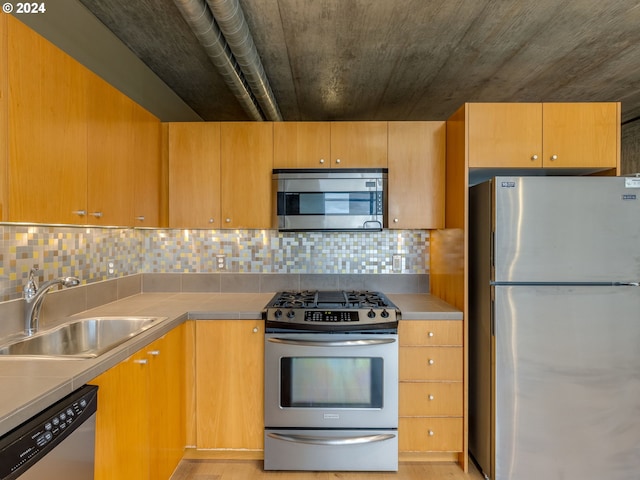 kitchen featuring light wood-type flooring, sink, appliances with stainless steel finishes, and tasteful backsplash