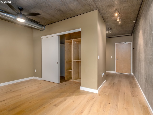 unfurnished bedroom featuring ceiling fan, a closet, and light hardwood / wood-style floors