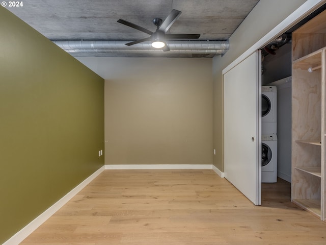 laundry room with light wood-type flooring, stacked washer / dryer, and ceiling fan