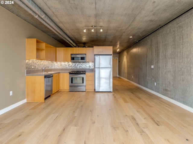 kitchen featuring light brown cabinets, sink, decorative backsplash, light wood-type flooring, and stainless steel appliances